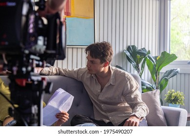 Young attractive man acting in front of the camera on the living room couch