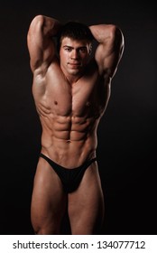 Young Attractive Man In A Black Bathing Suit Bodybuilder With Relief Muscles