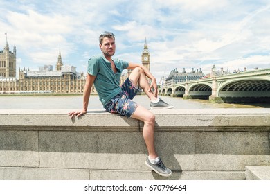 young attractive man at a bright summer day by the Big Ben and westminster bridge in London 