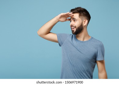 Young attractive man in casual clothes posing isolated on blue wall background, studio portrait. People lifestyle concept. Mock up copy space. Holding hand at forehead looking aside far away distance - Shutterstock ID 1506971900
