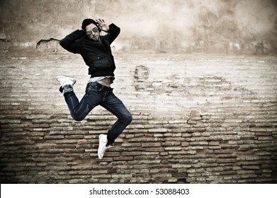 Young attractive man dancing in urban background