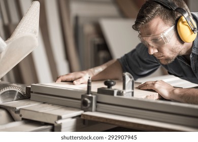 Young attractive man doing woodwork in carpentry