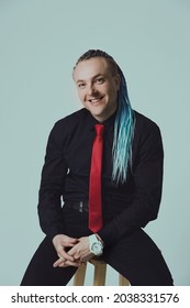 Young Attractive Man With An Interesting Haircut In Braids On An Undercut With A Red Tie On A Light Background.