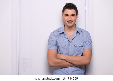 Young Attractive Man Standing Straight. Handsome Man Leaning Against Door