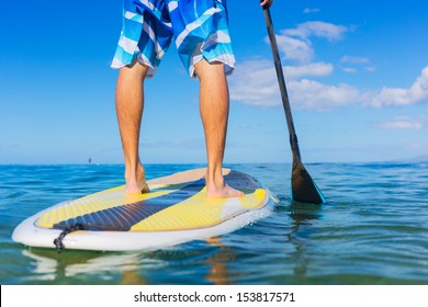 Young Attractive Mann on Stand Up Paddle Board, SUP, in the Blue Waters off Hawaii