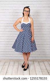 Young Attractive Pin Up Girl In A Vintage 1950's Dress Petticoat Dress Posing In Front Of A Stone Wall