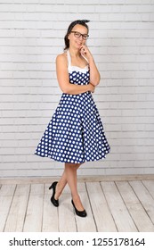 Young Attractive Pin Up Girl In A Vintage 1950's Dress Petticoat Dress Posing In Front Of A Stone Wall