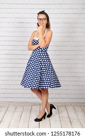 Young Attractive Pin Up Girl In A Vintage 1950's Dress Petticoat Dress Posing In Front Of A Stone Wall