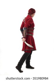 Young And Attractive Red Haired  Female Warrior,  Wearing A Red Medieval Tunic And Leather Armour.  Isolated On A White 