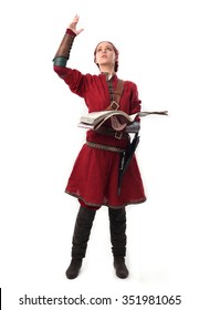 Young And Attractive Red Haired  Female Warrior,  Wearing A Red Medieval Tunic And Leather Armour.  Holding Magical Book. Isolated On A White 