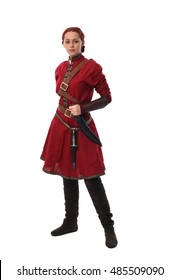 Young And Attractive Red Haired  Female Warrior,  Wearing A Red Medieval Tunic And Leather Armour.  Isolated On A White