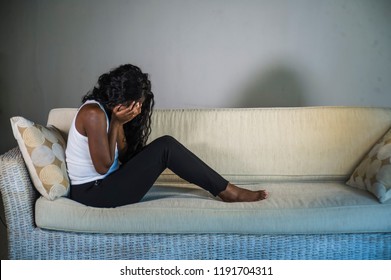 Young Attractive And Sad Black African American Woman Sitting Depressed At Home Sofa Couch Feeling Anxious And Frustrated Suffering Depression Problem And Anxiety Crisis Crying Desperate