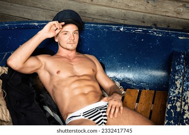 Young attractive sailor posing in the studio. Handsome man with a sexy body.