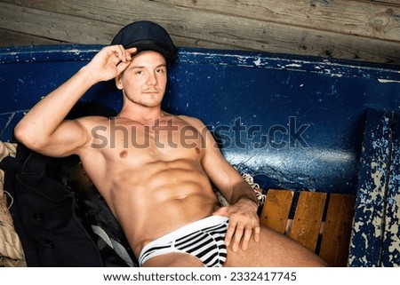 Young attractive sailor posing in the studio. Handsome man with a sexy body.