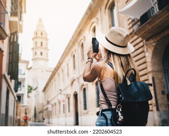 Young attractive smiling girl tourist exploring new city at summer - Shutterstock ID 2202604523