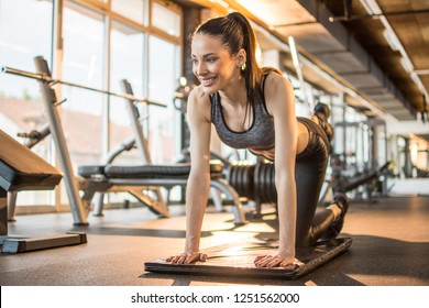 Young Attractive Sporty Girl Warming Up, Practicing Yoga, Doing Bird Dog Exercise, Donkey Kick Pose At Gym