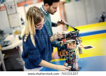 Young attractive students of mechatronics working on project
