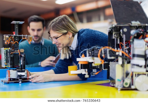 Young attractive students of mechatronics working
on project