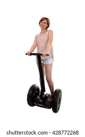 Young Attractive Tourist Woman With Red Hair Wearing Summer Shorts Smiling Happy Riding Electrical Segway Having Fun Driving Isolated On White Background In Ecological Transport Concept