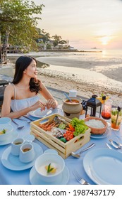 Young Attractive Travel Girl Enjoying Seafood Dinner On A Tropical Beach On The Background Of Beach And Nature Landscape