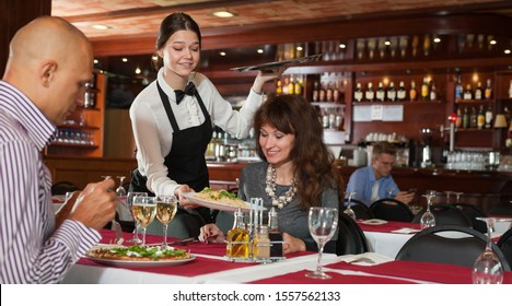 Young attractive waitress serving meals to elegant couple visited restaurant for lunch

 - Powered by Shutterstock