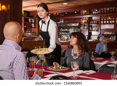 Young attractive waitress serving meals to elegant couple visited restaurant for lunch

 - Powered by Shutterstock