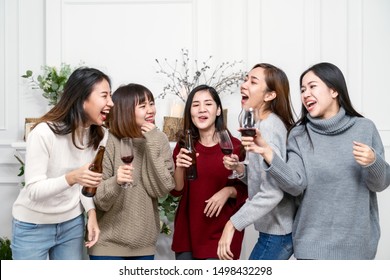 Junge attraktive Frau asian Gruppe von Freunden trinken, lachen und Spaß mit glücklich beim Treffen der Wiedervereinigung, Neujahr-Party und Weihnachtsfeier zu Hause. Vergnügen Sie sich in der Freizeit bei der lustigen Gruppe.