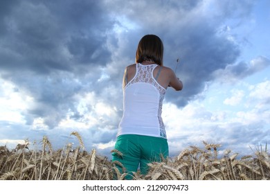Young attractive woman in the barley ripe field at evening time. Absorbing sun energy. Relaxing.