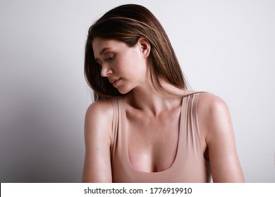 Young And Attractive Woman In Beige Cotton Top Looking Aside. Body Positive And Body Health Concept.