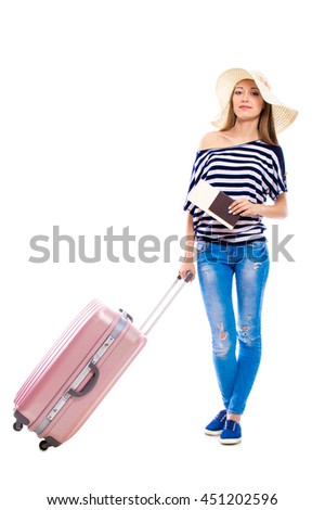 Young attractive woman in blue jeans and a hat with a suitcase isolated on white background. Recreation and tourism concept.