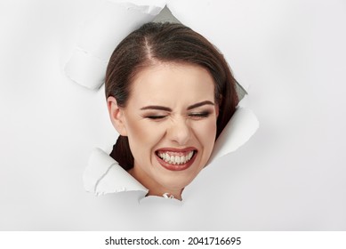 Young Attractive Woman Breaking Through Paper Wall