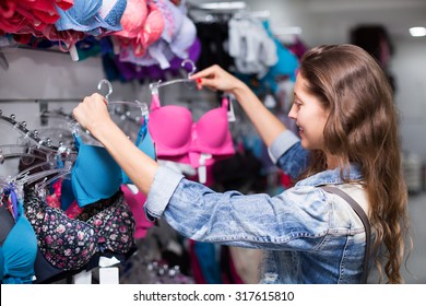 Young Attractive Woman Buying Brassiere In Clothing Store 