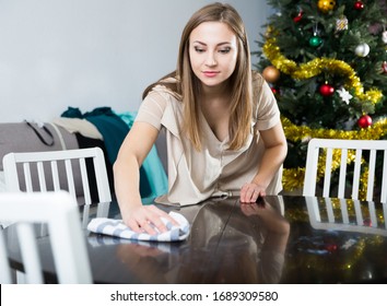 Young Attractive Woman Cleaning In House Before Christmas Celebration, Wiping Table

