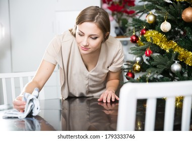 Young Attractive Woman Cleaning In House Before Christmas Celebration, Wiping Table

