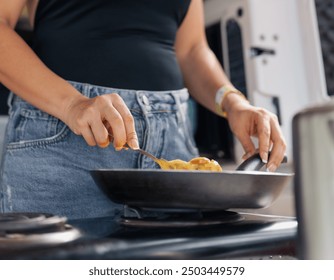 Young attractive woman cooking scramble eggs in the beach. - Powered by Shutterstock