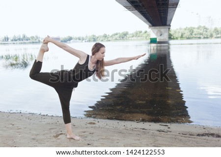 Young attractive woman doing dancers yoga pose outdoor