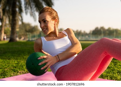 A Young Attractive Woman Doing The Russian Twist At The Public Park