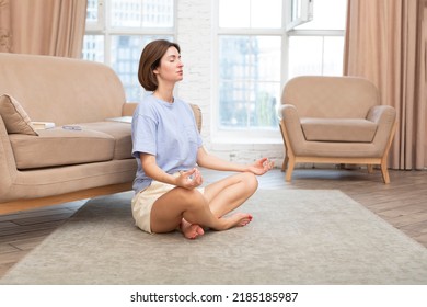 Young Attractive Woman Doing Yoga On The Floor At Home. Stressful Day And Calm Down Concept