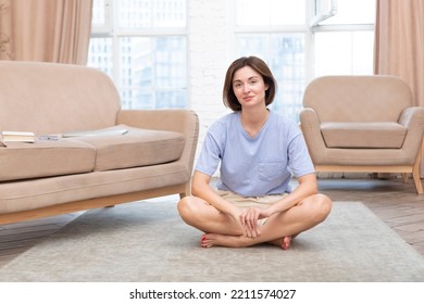 Young Attractive Woman Doing Yoga On The Floor At Home. Stressful Day And Calm Down Concept	