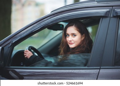 Young Attractive Woman Driving The Car In Rain