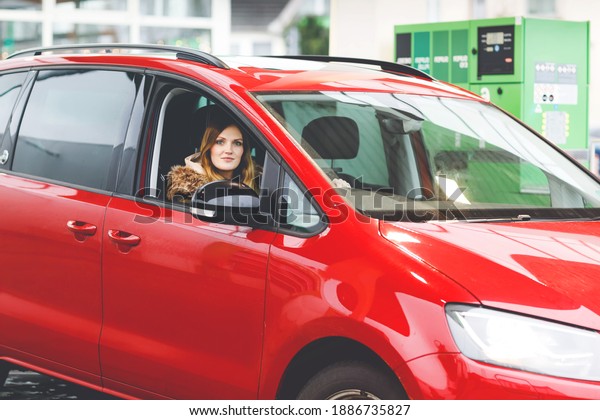Young attractive woman with happy positive\
expression, being satisfied with unforgettable journey by car, sits\
on driver seat. People, driving, transport concept. Winter ski\
holiday by car
