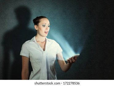 Young Attractive Woman Holding A Cell Phone In A Dark Room At Her Glow From The Monitor