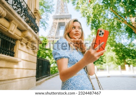 Young attractive woman making selfie photo using mobile phone near Eiffel Tower in Paris France, Woman tourist travelling on Europe 