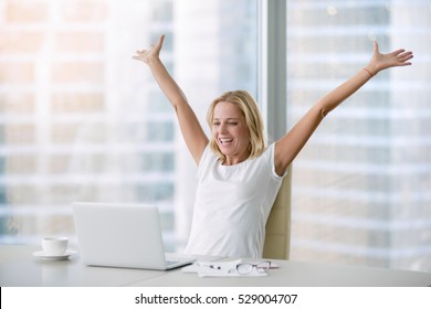 Young Attractive Woman At A Modern Office Desk, With Laptop, Stretching Her Arms With Extreme Joy Special Prize Winner, Office Holiday Party, Found A Job, Got A Date Invitation, End Of The Working Day