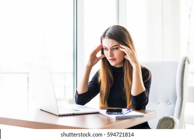 Young Attractive Woman At Modern Office Desk, Working On Laptop, Massaging Temples To Forget About Constant Headaches,