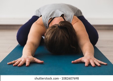 Young Attractive Woman On Yoga Mat Doing Child's Pose