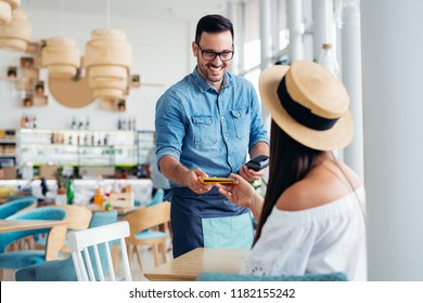 A Young And Attractive Woman Paying The Bill In A Restaurant