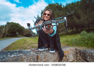 Young attractive woman pilot with remote control ready to flying drone in the city park