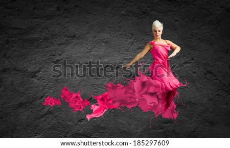 Young attractive woman in pink dress jumping high