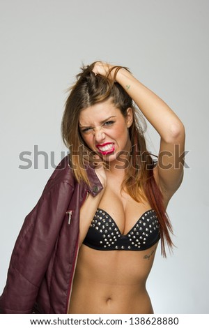 Young attractive woman posing with crazy expression on white background